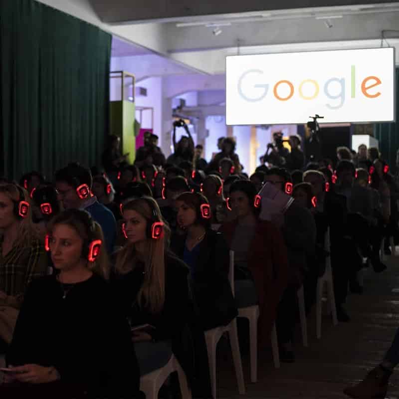 Silent Meeting Google Κοινό με κόκκινα ασύρματα ακουστικά LED σε εκδήλωση της Google