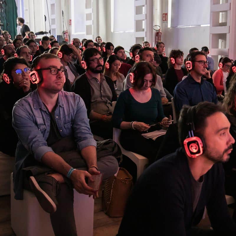 Meeting Lab Silentsystem Καθισμένο κοινό με κόκκινα ασύρματα ακουστικά LED σε συνάντηση