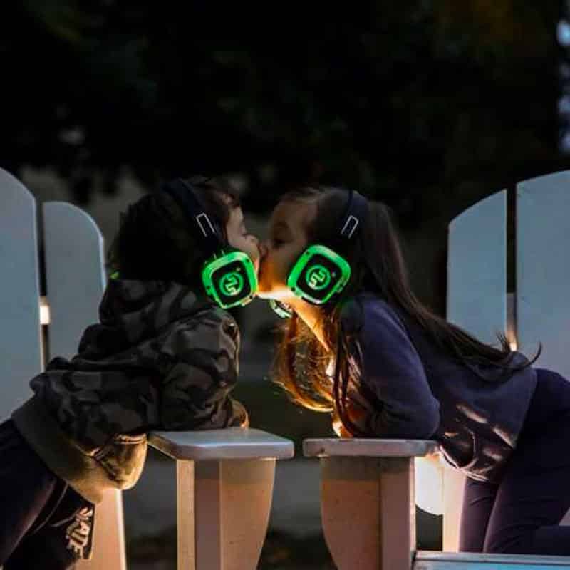kids-silentexperience Δύο κορίτσια με πράσινα ακουστικά LED αγκαλιάζονται το βράδυ