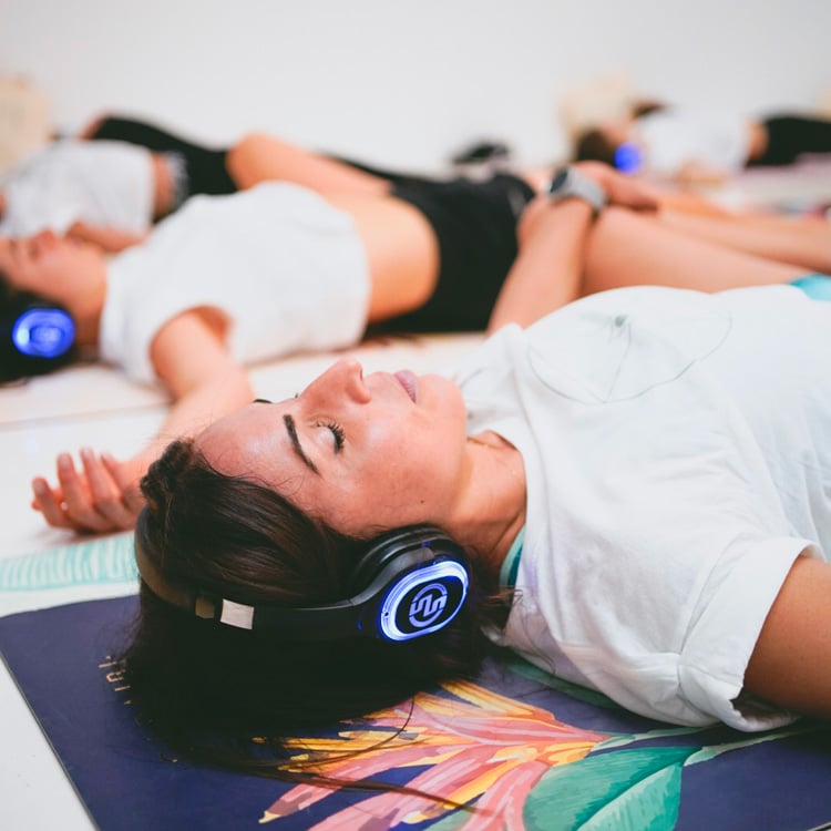 inspirafit Γυναίκες ξαπλωμένες με ασύρματα ακουστικά σε μάθημα Silent Fitness