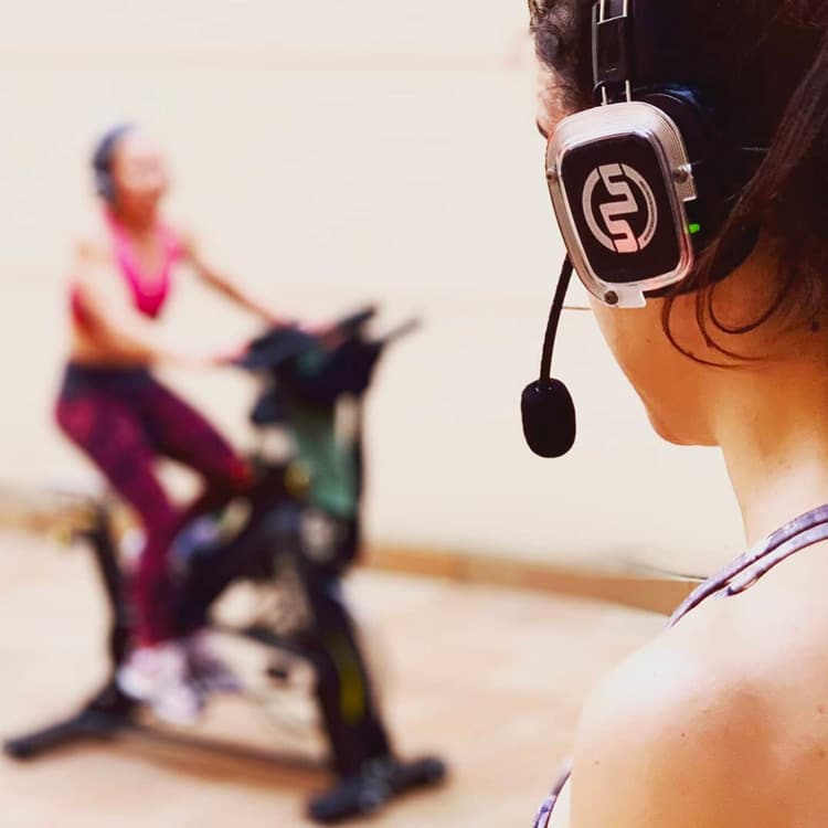 spinning-milano Εκπαιδευτής spinning με μικρόφωνο κεφαλής κατά τη διάρκεια μαθήματος στο Μιλάνο