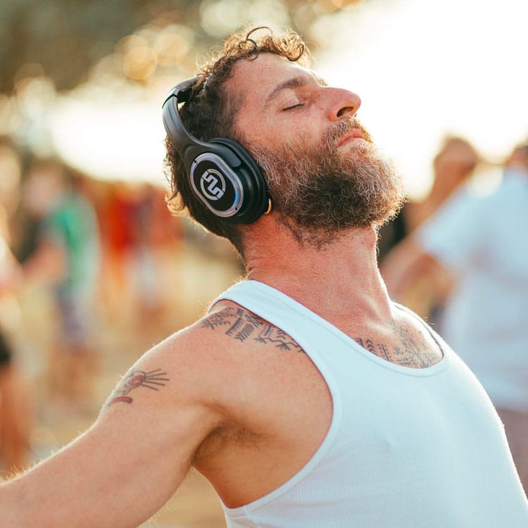 yoga-kalemana Άνδρας αναπνέει με κλειστά μάτια φορώντας ασύρματα ακουστικά κατά τη yoga