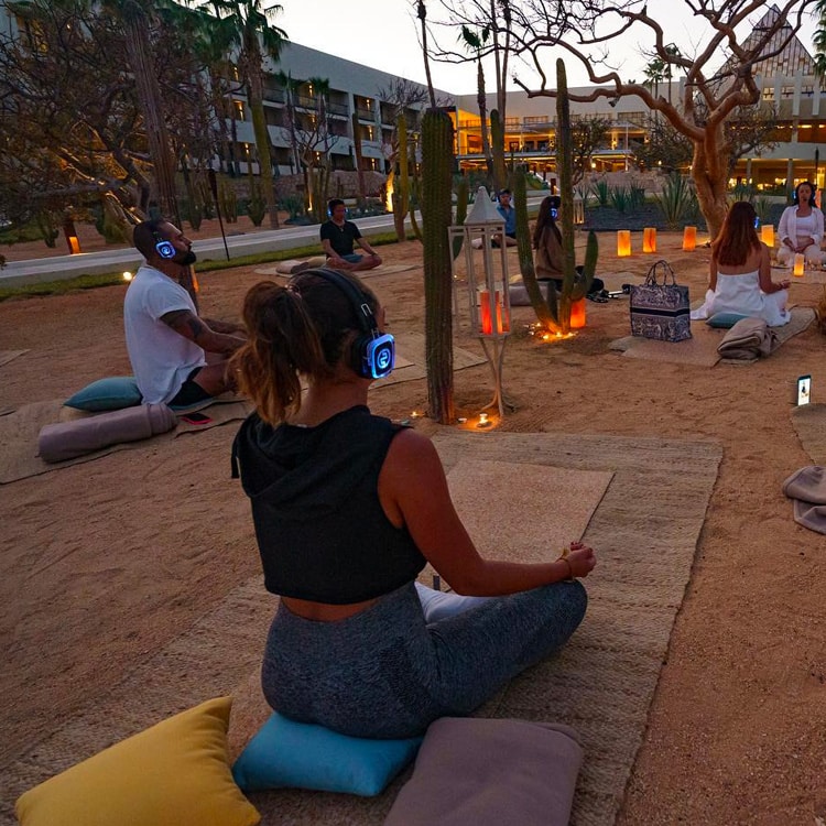 yogasensoriale Αισθητηριακή yoga στο ηλιοβασίλεμα με ασύρματα ακουστικά και κεριά