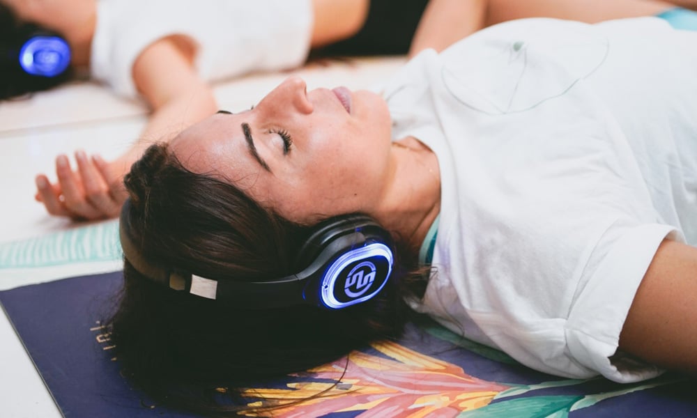 Meditazione con cuffie Γυναίκα ξαπλωμένη με ασύρματα ακουστικά σε καθοδηγούμενο διαλογισμό