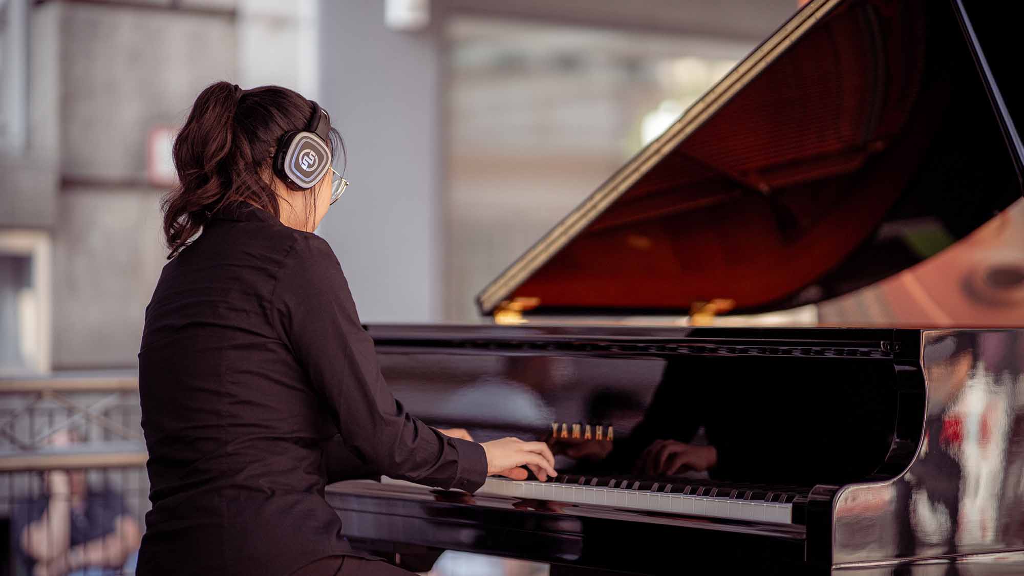 Pianista con pianoforte Yamaha Silent e cuffie wireless Silentsystem Συναυλίες πιάνου με ασύρματα ακουστικά: ο πλήρης οδηγός
